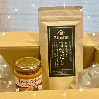 ダンボールにに久世福商店のだしとパスタソースが入っている