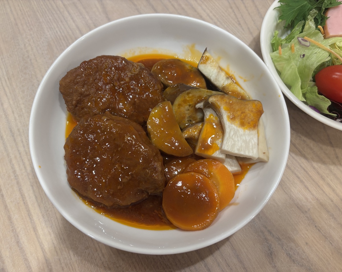 皿に盛り付けた煮込みハンバーグと温野菜