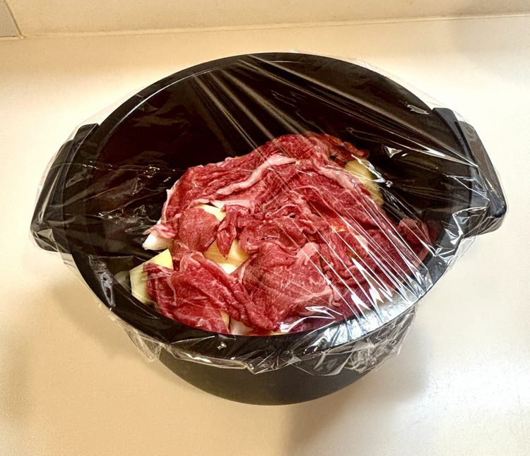 材料を重ね入れた内鍋にラップをかけた状態