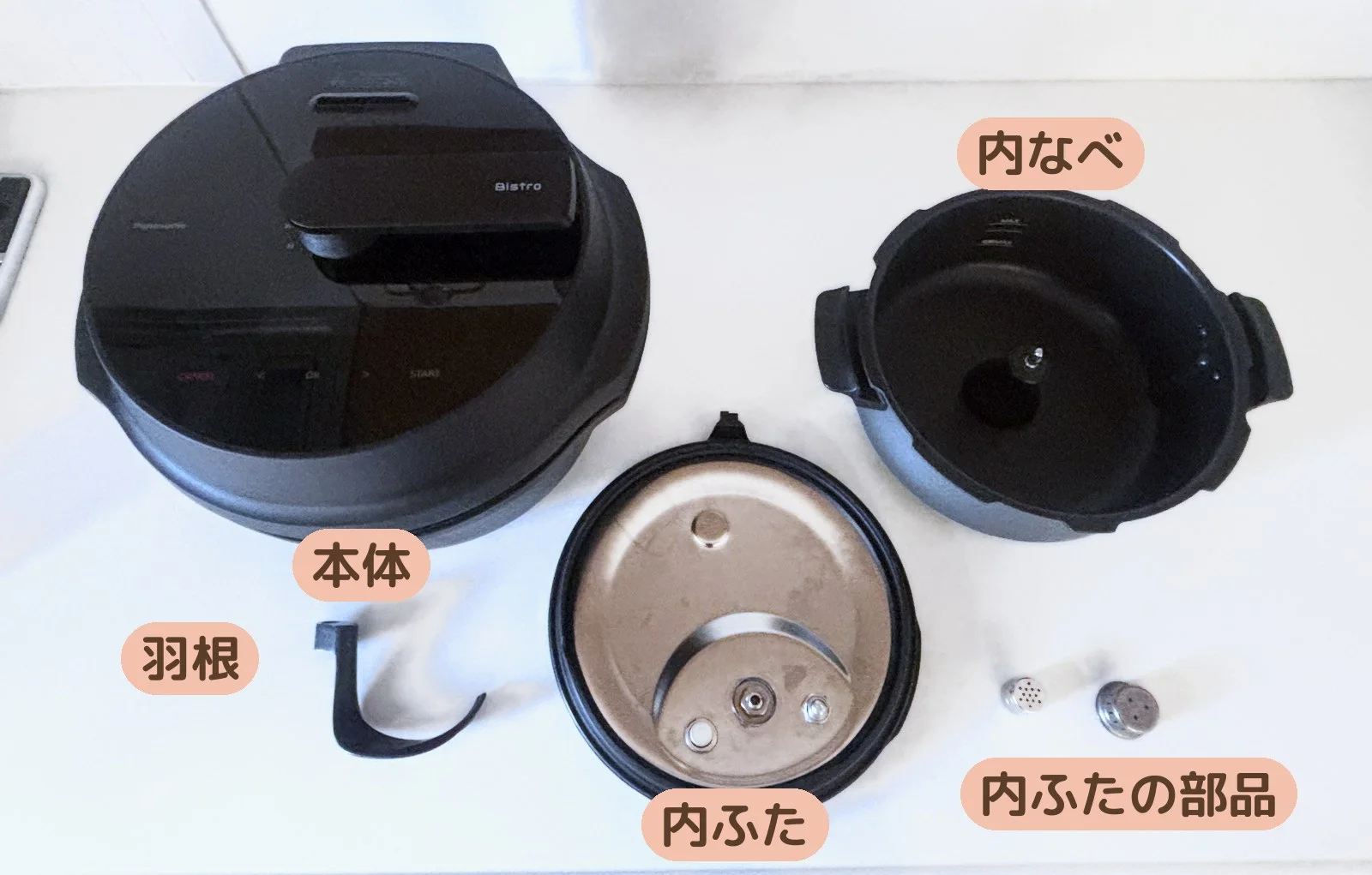 オートクッカービストロを分解して並べたところ。本体・内なべ・内ふた・羽根・内ふたの部品
